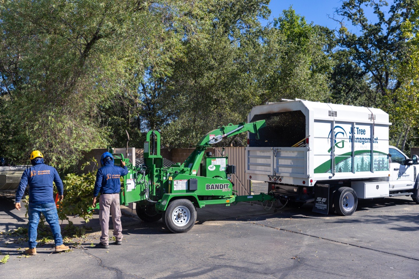 JG Landscape Management crew feeding branches into a wood chipper